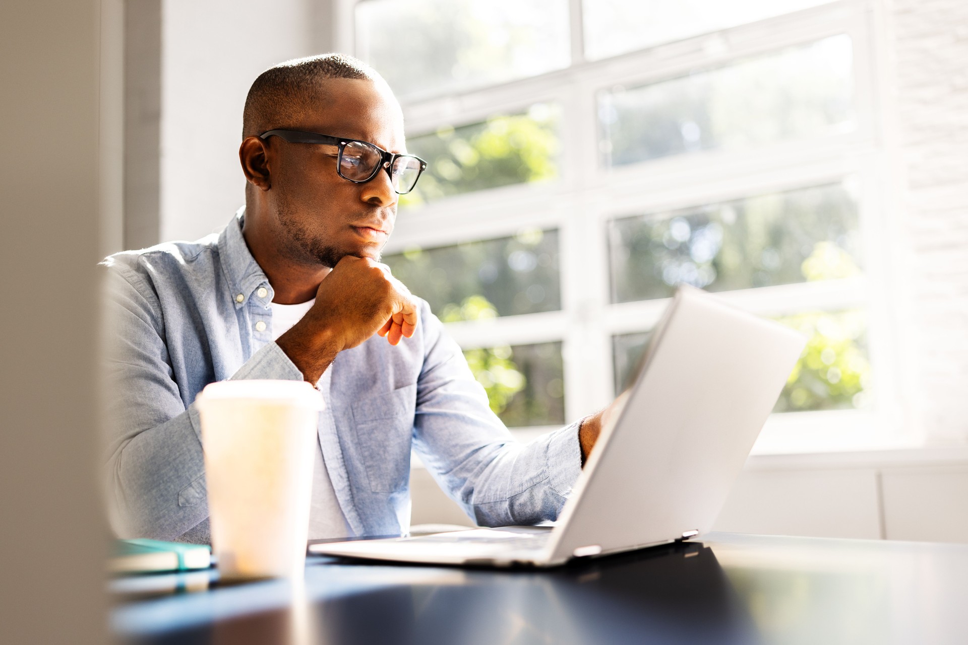 Young African American businessman studying legal cases on laptop